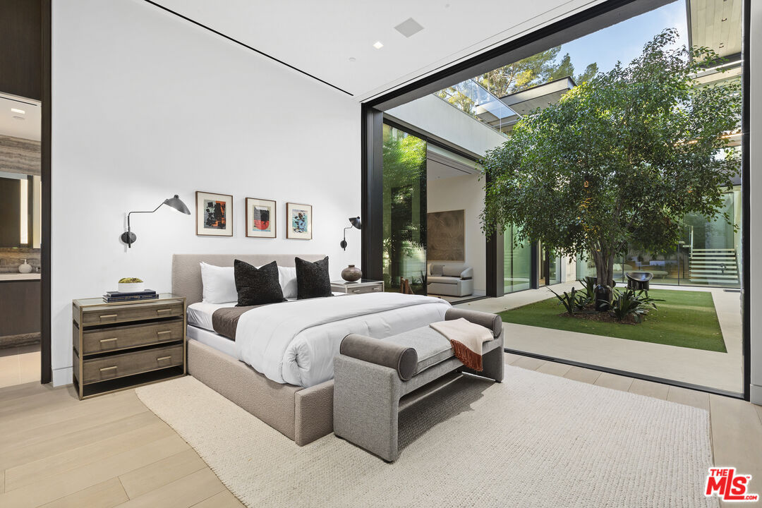 Luxury bedroom with glass wall opening to a private courtyard